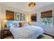 Comfortable bedroom with a queen bed, neutral tones, and natural light from two windows at 3975 S Logan St, Englewood, CO 80113