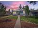 Inviting single-story home featuring beautiful landscaping and a walkway leading to the front door at 3975 S Logan St, Englewood, CO 80113