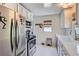 Functional kitchen with stainless steel appliances, white cabinets, and a window at 3975 S Logan St, Englewood, CO 80113