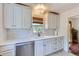 Charming kitchen featuring white cabinets, quartz countertops, and a stainless steel dishwasher at 3975 S Logan St, Englewood, CO 80113