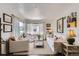 Bright living room featuring hardwood floors, white furniture, and plenty of natural light from the windows at 3975 S Logan St, Englewood, CO 80113
