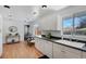 Bright kitchen with white cabinets, wood floors, and modern appliances at 6642 S Bridger Ct, Centennial, CO 80121