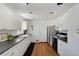 White kitchen cabinets, black appliances, and hardwood floors at 6642 S Bridger Ct, Centennial, CO 80121