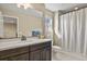 Bathroom featuring a dark vanity, shower/tub combination, and a large mirror at 7976 E 53Rd Dr, Denver, CO 80238