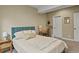 Neutral bedroom with an emerald headboard and side table featuring a stylish lamp at 7976 E 53Rd Dr, Denver, CO 80238