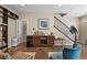 Stylish living area featuring a modern bar cabinet, hardwood floors, and staircase access at 7976 E 53Rd Dr, Denver, CO 80238