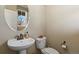 Elegant powder room with a pedestal sink, oval mirror, and modern fixtures at 7976 E 53Rd Dr, Denver, CO 80238