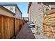 Wide view of the side yard with a stone walkway and wooden fence at 7976 E 53Rd Dr, Denver, CO 80238