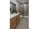 Modern bathroom showcasing a glass-enclosed shower, sleek wooden cabinets, and stylish fixtures at 17055 W 92Nd Loop, Arvada, CO 80007