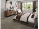 Cozy bedroom with stylish accents, decorative dresser, and large windows providing natural light and backyard views at 17055 W 92Nd Loop, Arvada, CO 80007