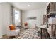 Home office with two armchairs, a desk, and built-in shelving at 13455 Valentia Pl, Thornton, CO 80602