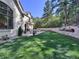 Landscaped backyard with a large lawn and stone retaining wall at 1043 Meteor Pl, Castle Rock, CO 80108