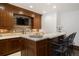 Basement wet bar with wooden cabinetry and a granite countertop at 1043 Meteor Pl, Castle Rock, CO 80108