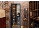 Well-stocked wine cellar with brick walls and extensive storage at 1043 Meteor Pl, Castle Rock, CO 80108