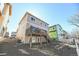 Multi-story home featuring a wooden deck and staircase leading down to gravel landscaping at 3565 E 141St Dr, Thornton, CO 80602
