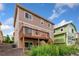 Back exterior view featuring a wooden deck, small yard, and a multi-story house at 3565 E 141St Dr, Thornton, CO 80602
