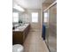 Clean bathroom featuring dual sinks, and a glass-enclosed shower stall at 3565 E 141St Dr, Thornton, CO 80602