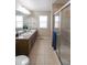 Bathroom featuring double sinks, granite counters, and separate shower stall, designed for convenience and comfort at 3565 E 141St Dr, Thornton, CO 80602