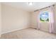 Bright, carpeted bedroom with a large window framed by pink curtains, providing natural light and a soft ambiance at 3565 E 141St Dr, Thornton, CO 80602