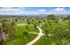 Aerial view of community park featuring walking paths, mature trees, and playground equipment at 3565 E 141St Dr, Thornton, CO 80602