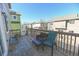 Outdoor wooden deck is furnished with black chairs, a small table, and a green chair at 3565 E 141St Dr, Thornton, CO 80602