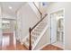 Bright entryway featuring hardwood floors, a staircase with wood railing, and a powder room at 3565 E 141St Dr, Thornton, CO 80602