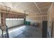 Unfinished garage with a concrete floor, an open ceiling, a garage door with windows, and a storage area at 3565 E 141St Dr, Thornton, CO 80602