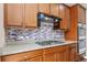 Close-up of kitchen showcasing granite countertops, a gas cooktop, and tiled backsplash at 3565 E 141St Dr, Thornton, CO 80602