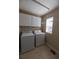 Functional laundry room with washer, dryer, and white cabinets providing ample storage space at 3565 E 141St Dr, Thornton, CO 80602