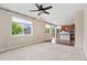 Bright living room featuring a ceiling fan, large windows, and access to the kitchen area at 3565 E 141St Dr, Thornton, CO 80602