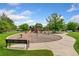 Community playground area with slides, swings, and climbing structures, surrounded by a walking path at 3565 E 141St Dr, Thornton, CO 80602