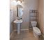 Cozy powder room features a pedestal sink, neutral paint, tile flooring, and modern shelving at 3565 E 141St Dr, Thornton, CO 80602