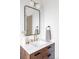 Modern bathroom vanity with wood cabinets, white countertop, gold fixtures, and a sleek mirror at 3201 Albion St, Denver, CO 80207