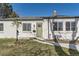 Charming white brick home featuring a well-kept front yard and a quaint olive front door at 3201 Albion St, Denver, CO 80207