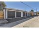 Garage row showing multiple parking spots with a paved driveway, and wooden fences at 3201 Albion St, Denver, CO 80207