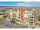 Full building exterior view showcasing complex architecture, colorful accents, ample parking, and landscaping at 1044 Rockhurst Dr # 401, Highlands Ranch, CO 80129