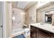 Well-lit bathroom features a glass-enclosed shower with a seat, a single-sink vanity, and neutral tiling at 1044 Rockhurst Dr # 401, Highlands Ranch, CO 80129