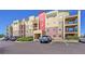 A modern condo building with balconies, brick accents, and ample parking on a clear, sunny day at 1044 Rockhurst Dr # 401, Highlands Ranch, CO 80129
