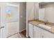 Bathroom featuring a vanity with granite countertop, white cabinets, and a tiled shower, designed for modern living at 819 Sunflower Dr, Brighton, CO 80601