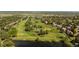 Stunning aerial view showcasing a golf course and lake with lush greenery and trees in the background at 2535 W 115Th Dr, Westminster, CO 80234