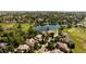 Aerial view showcasing a neighborhood by a lake, lush trees, and a golf course at 2535 W 115Th Dr, Westminster, CO 80234