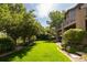 Well-manicured backyard with a lush lawn, mature trees, and a partial view of the house with a balcony at 2535 W 115Th Dr, Westminster, CO 80234