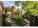 Landscaped backyard with stone pathways, mature trees, and an outdoor dining area at 2535 W 115Th Dr, Westminster, CO 80234