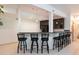 Basement bar area with dark wood cabinets, pendant lighting, and bar stool seating at 2535 W 115Th Dr, Westminster, CO 80234
