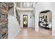 Bright, inviting foyer showcasing a staircase with stone accent wall and an adjacent dining area at 2535 W 115Th Dr, Westminster, CO 80234