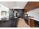 Open kitchen with a large island, modern appliances, and sleek black and wood cabinetry at 2535 W 115Th Dr, Westminster, CO 80234