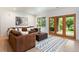 Cozy living room with a brown sectional, decorative rug, and French doors leading to the backyard at 2535 W 115Th Dr, Westminster, CO 80234