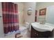 Cozy bathroom features a shower-tub combo with a stylish curtain, a toilet, and a vanity with a sink at 2991 S Zeno Way, Aurora, CO 80013