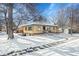 Ranch style home with snow covered yard at 749 Poplar St, Denver, CO 80220