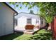 Backyard features a stone patio with a comfortable sitting area surrounded by mature trees and a well-maintained lawn at 1522 Willow St, Denver, CO 80220